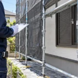 外壁塗装中の足場まわりを点検する幸家リフォームの職人（説明用イメージ）